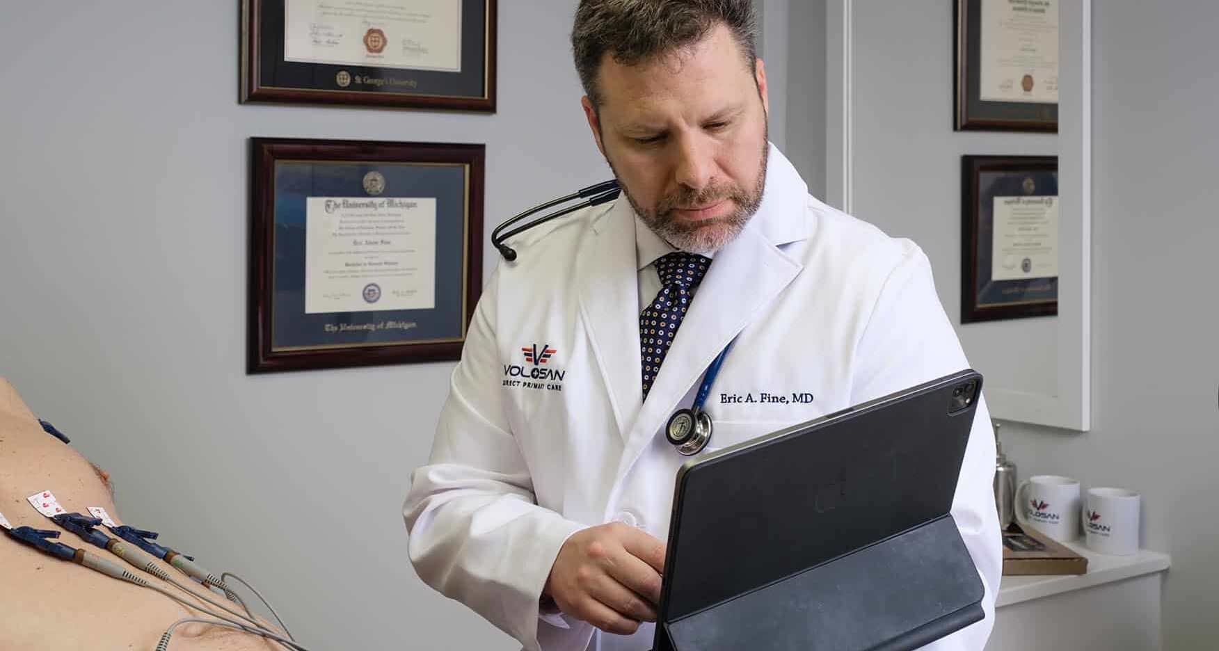 Dr Fine running tests on a patient in exam room, consulting a tablet