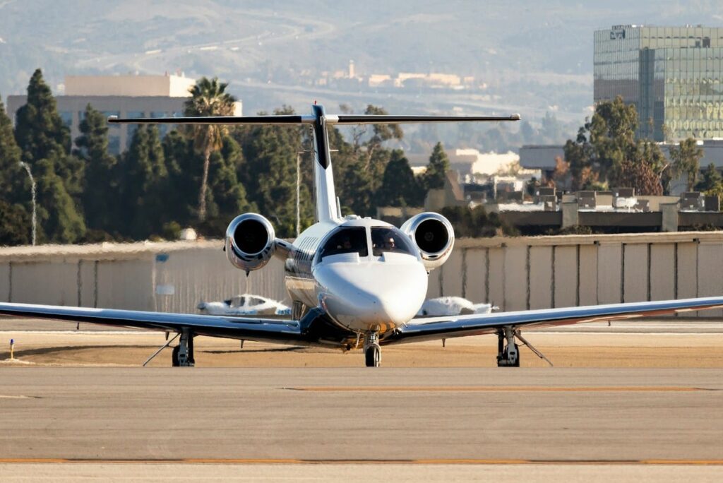 Private jet on an airport runway taxiing towards camera