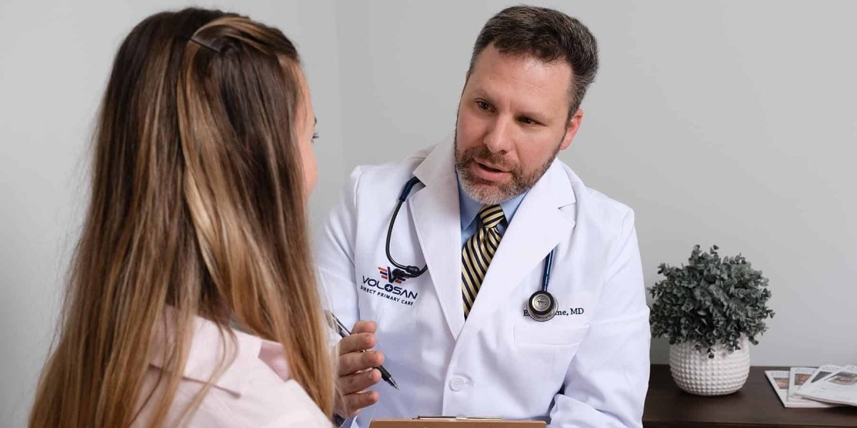 Dr Fine consulting with a female patient in an exam room.